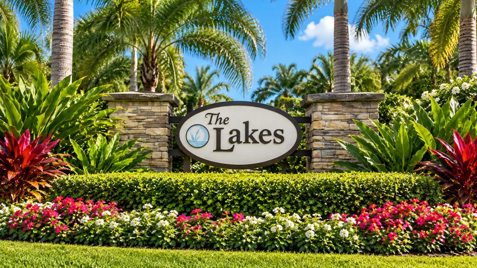 The Lakes at The Bluffs Jupiter entrance sign with tropical palms and flowers